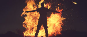 kiégés - egy ember áll fáklyával a tűz előtt